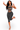 A woman modeling a dark gray washed two-piece activewear set featuring a strappy cutout crop top and matching high-waisted leggings, posing against a white background.