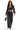 A woman modeling a matching two-piece outfit consisting of a dark gray washed long-sleeve crop top with a deep V-neck and matching wide-leg drawstring pants, holding a small black handbag against a plain white background.