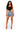 A woman modeling a black sleeveless crop top and high-waisted, heavily distressed denim shorts with frayed hems, paired with clear high-heeled sandals, against a plain white background.