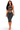 A woman modeling a dark gray two-piece set consisting of a strappy cutout halter crop top and matching high-waisted cropped leggings with silver contrast stitching, on a white background.