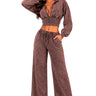 A woman modeling a matching two-piece lounge set in a washed brown color, featuring a cropped zip-up hoodie with long sleeves and matching wide-leg drawstring pants, set against a plain white background.