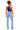 A woman shown from the back wearing a bright blue sleeveless crop top and light-wash blue jeans, standing against a plain white studio background.