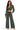 A woman modeling a matching two-piece outfit consisting of a dark gray-green cropped long-sleeve top with a front zipper and drawstring, paired with wide-leg pants in the same washed dark gray-green fabric, against a plain white background.