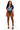 A woman modeling a two-piece outfit consisting of a blue short-sleeve graphic crop top with a plunging neckline and brown high-waisted sheer mesh leggings, paired with black lace-up platform heels, against a plain white background.