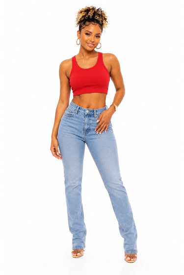 A woman modeling a bright red cotton crop top and light-wash blue high-rise jeans against a plain white background.